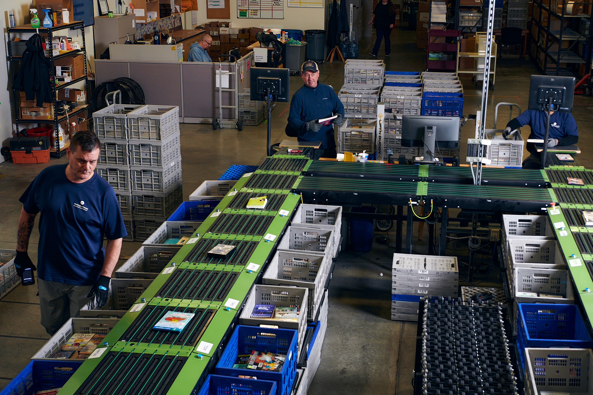 Staff working in courier materials sorting warehouse