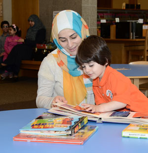 Mujer y niño leyendo un libro juntos