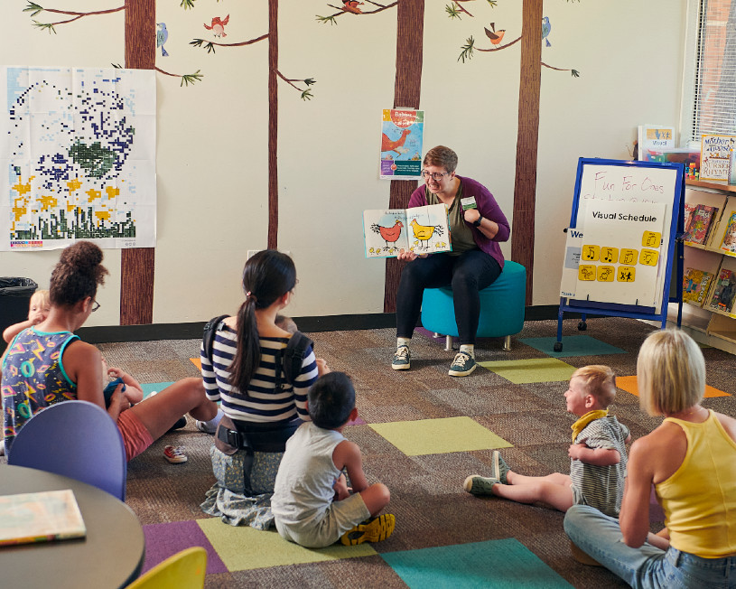Young children and their caregivers gather for storytime.