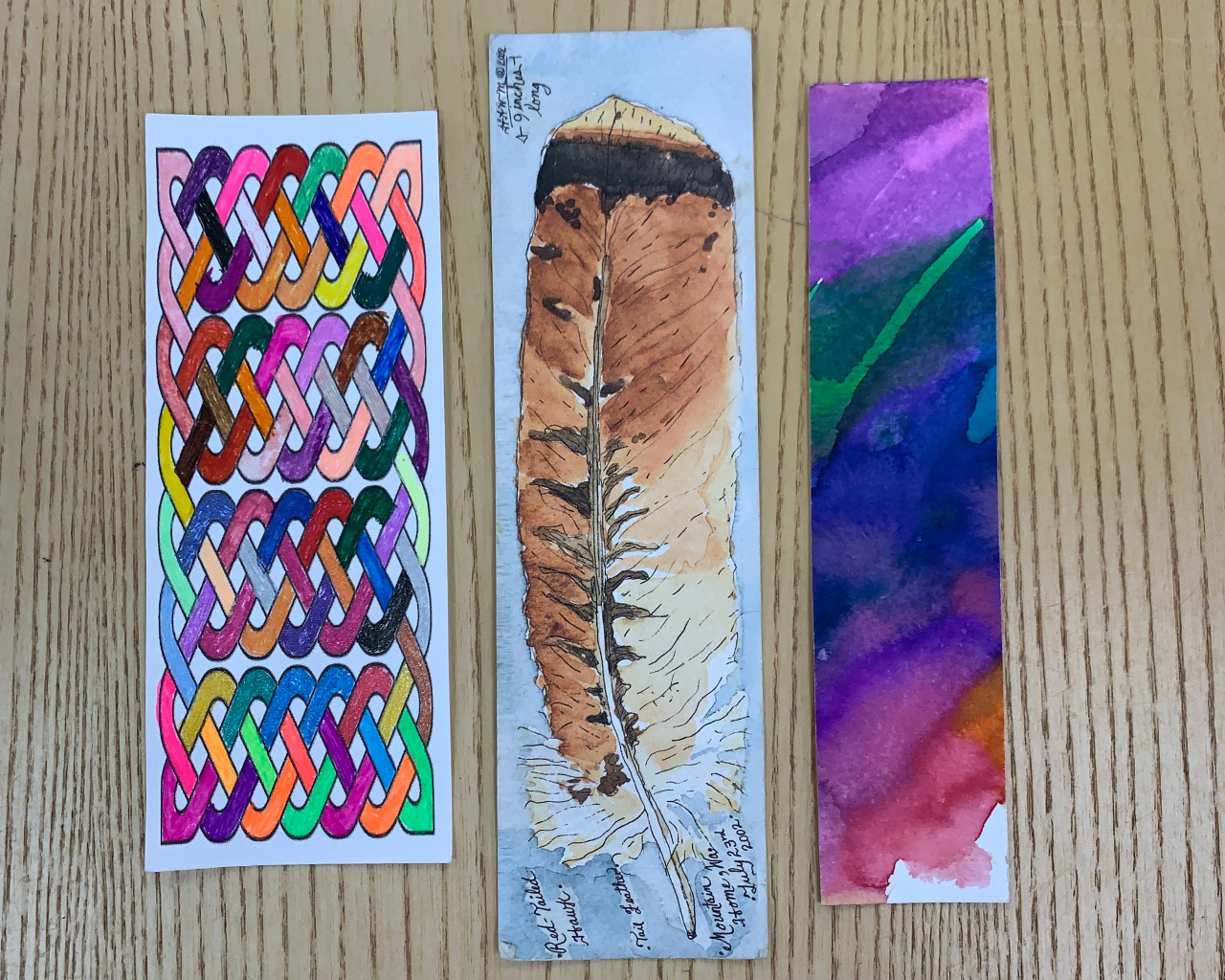 3 colorful bookmarks on a wooden backdrop