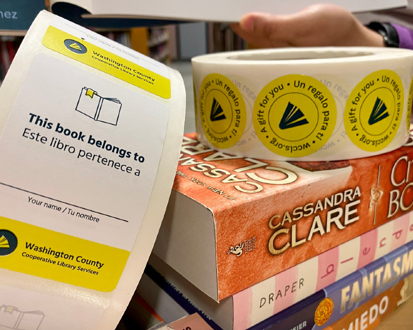 stack of children's books with WCCLS bookplates and stickers