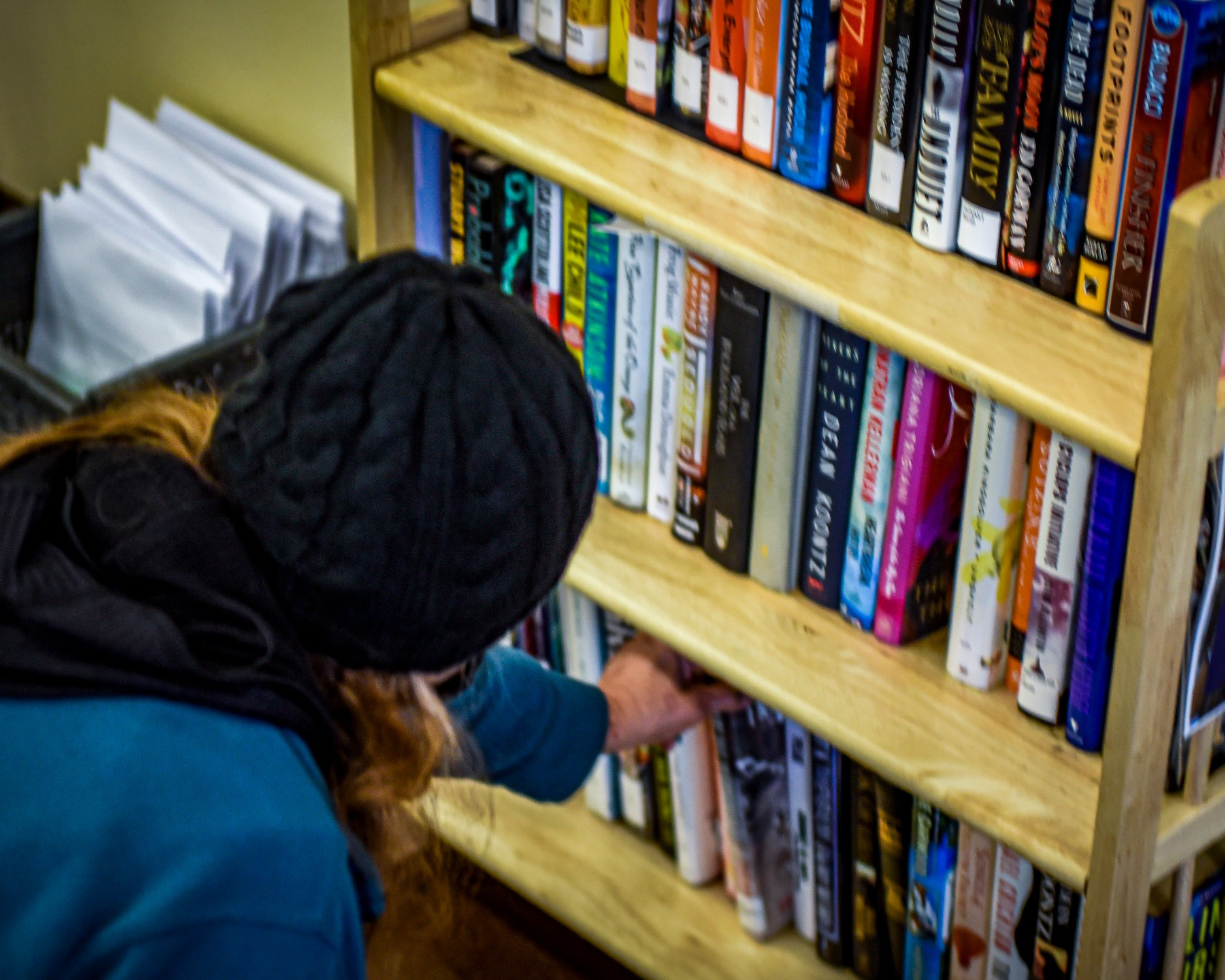 persona hojeando libros de un estante