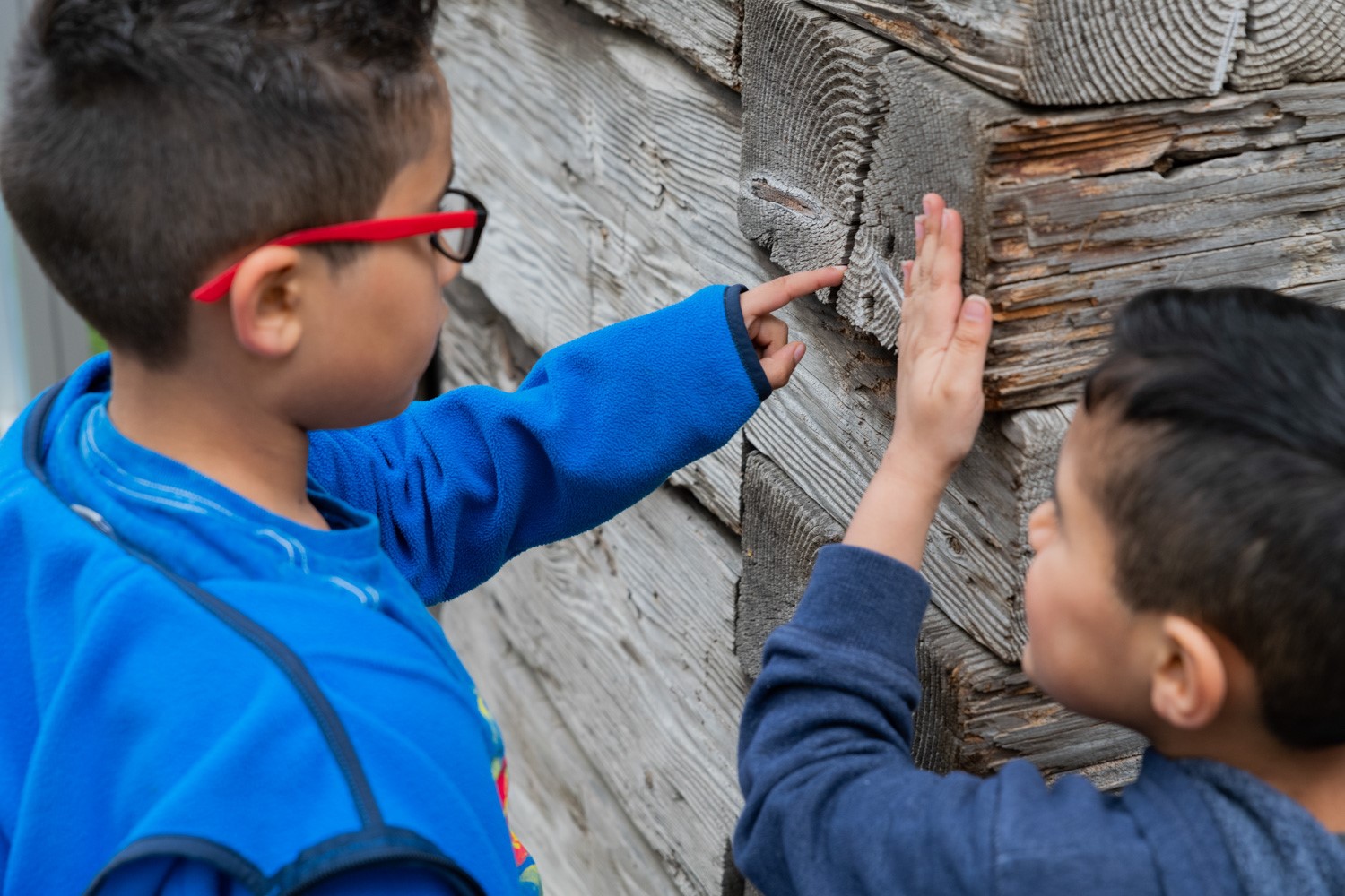 Boys examining old wood wall