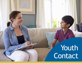 smiling woman and young boy sitting on couch looking at each other