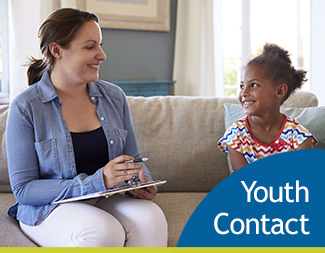 smiling woman and young girl sitting on couch looking at each other