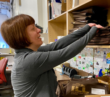 Mujer empacando materiales de la biblioteca para enviarlos por correo