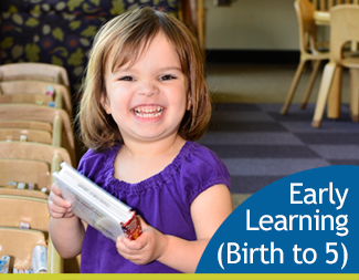 Smiling toddler girl holding a book