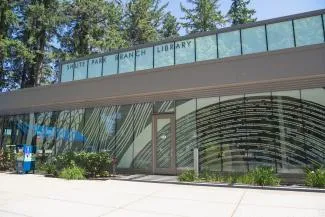 Exterior of modern glass library with sign that says Shute Park Branch Library