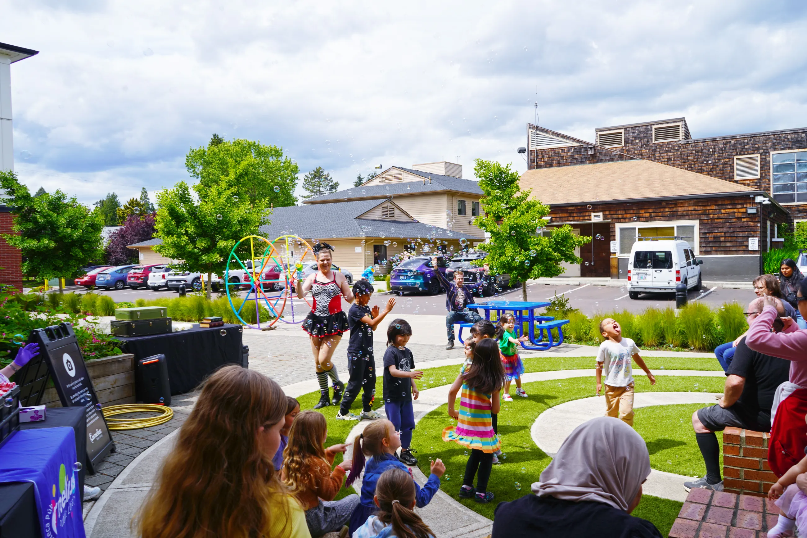 Community members sit outside and enjoy a performance.