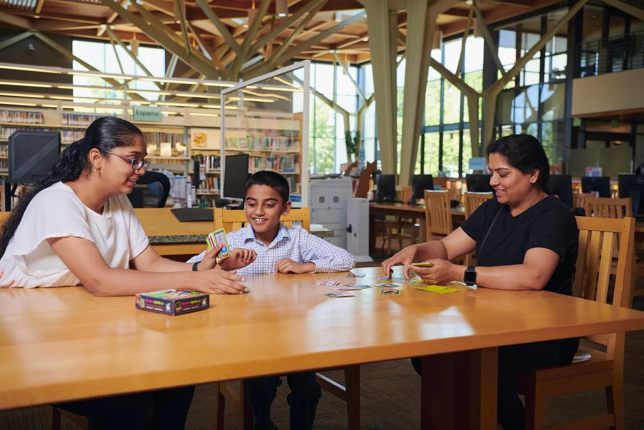 Family playing board games at the library.