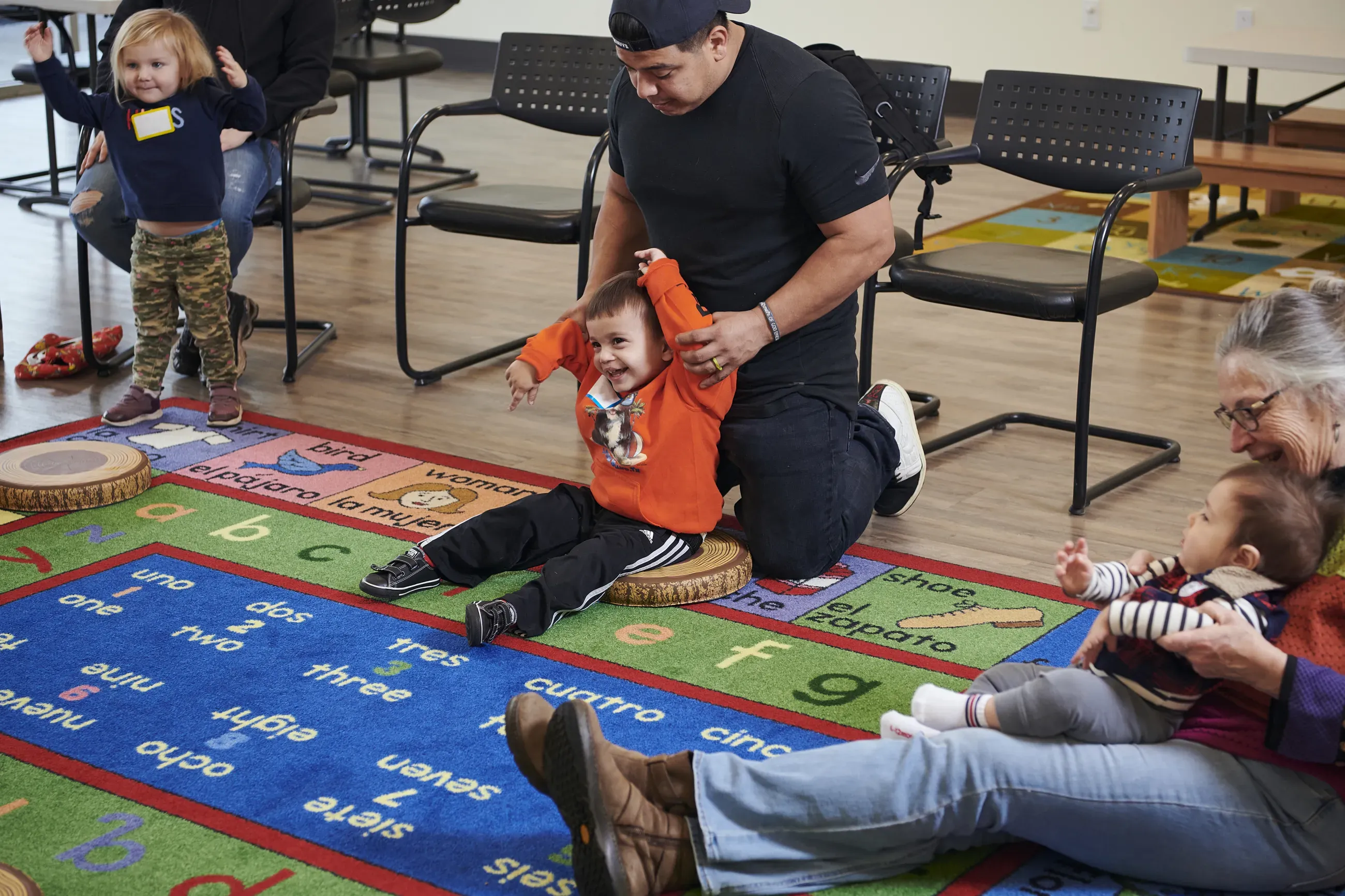 Parents and children play on the floor during library Storytime.