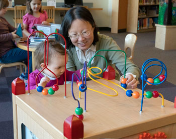 Mujer y niño jugando con cubos de cuentas