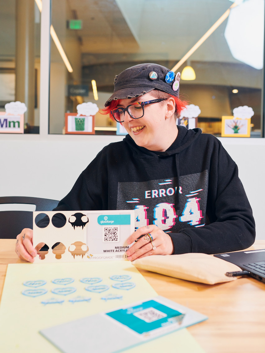 Adolescente usando Glowforge en el makerspace de la biblioteca