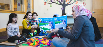Woman reading books to children