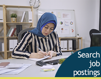 Woman in headscarf writing at desk